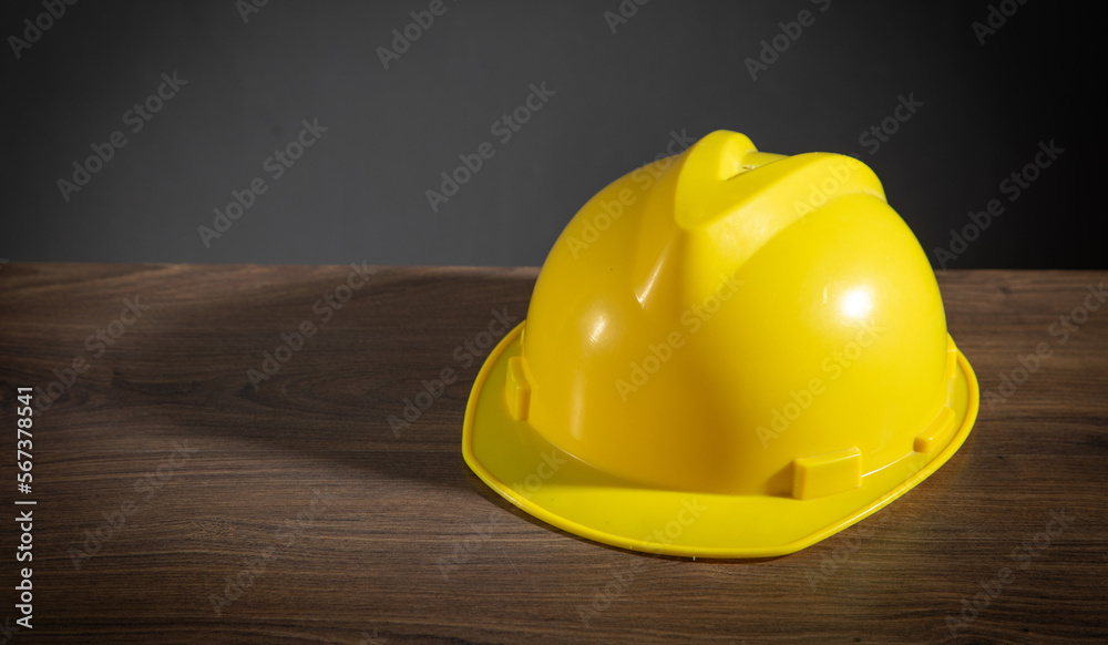 Yellow construction helmet on the wooden table. Yellow construction helmet on the wooden table.