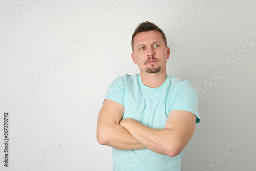 Smiling handsome man in blue shirt standing with crossed arms