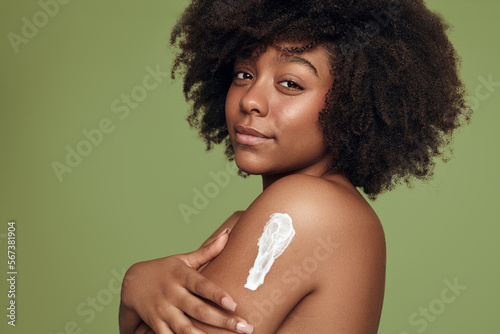 African American woman smearing cream on arm