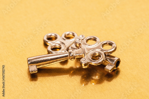 Two steel keys on golden metal background