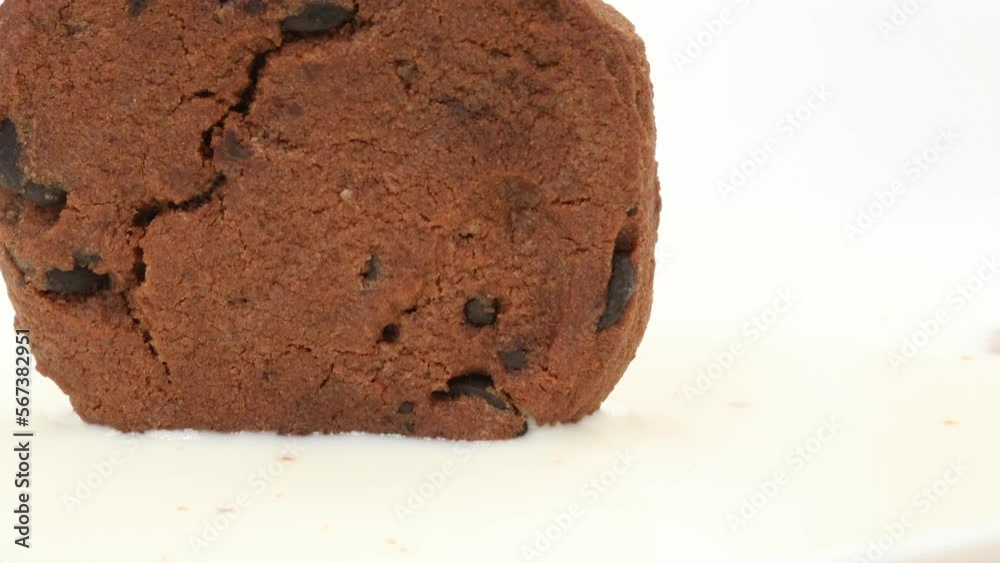 chocolate chip cookies dipped in a mug of milk. drops of milk flow down from pastries. baking close-up. High quality 4k footage chocolate chip cookies dipped in a mug of milk. drops of milk flow down from pastries. baking close-up. High quality 4k footage