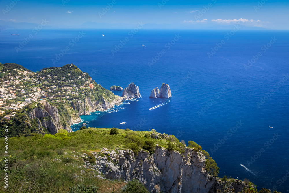 Above Capri city cliffs and Faraglioni with boats and yacht, amalfi coast, Italy