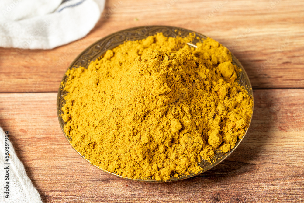 Curry Masala Powder. Turmeric powder or curry powder spice in a bowl on wooden background. İndian spices. Dry spice concept. close up Curry Masala Powder. Turmeric powder or curry powder spice in a bowl on wooden background. İndian spices. Dry spice concept. close up
