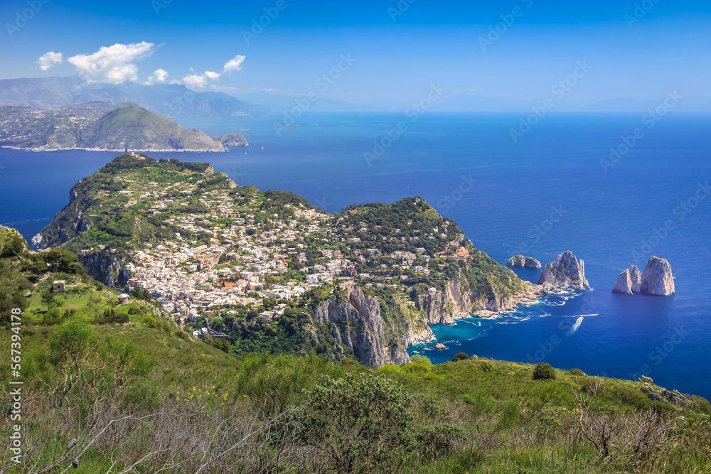 Above Capri city cliffs and Faraglioni with boats and yacht, amalfi coast, Italy