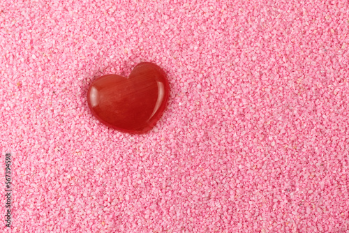 Red heart-shaped rocks on a pink beach