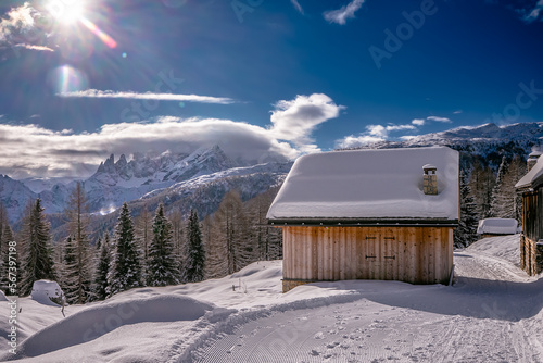 Baita in legno in panorama invernale con neve photo
