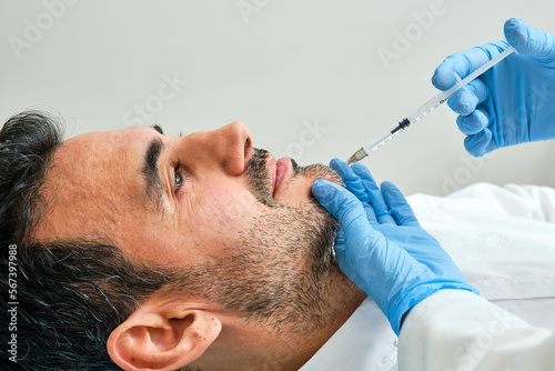 45-year-old dark-haired man in an aesthetic clinic being treated with botulinum toxin