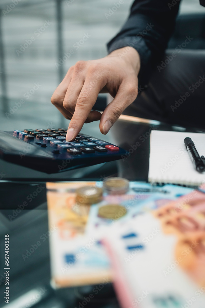 Fototapeta premium Geld zählen mit Taschenrechner