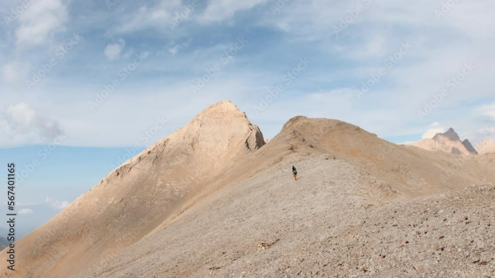 climber goes on a mountain slope. A girl with a backpack is engaged in mountaineering. trekking in the mountains climber goes on a mountain slope. A girl with a backpack is engaged in mountaineering. trekking in the mountains