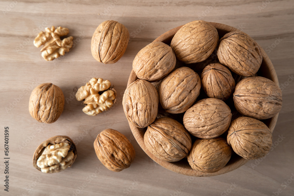 Peeled walnuts and whole walnuts in wooden bowl
Peeled walnuts and whole walnuts in wooden bowl