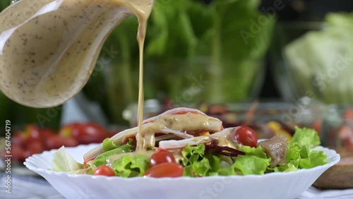 woman chef mix fresh baby cos salad and pour salad dressing in glass blow. Organic Vegetables mix all green salad In glass bowl. Breakfast fresh salad and clean vegetable.