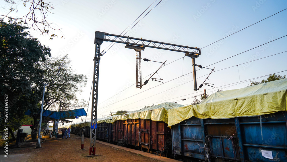 indian railway station loader train standing in junction, metal pole with electric cable, low angle shot, locomotive transportation technology