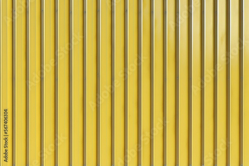 A corrugated fence of yellow metal sheets with screw. Texture of metal fence picket Profile decking. Internal primed side of a metal picket fence. Profiled metal_