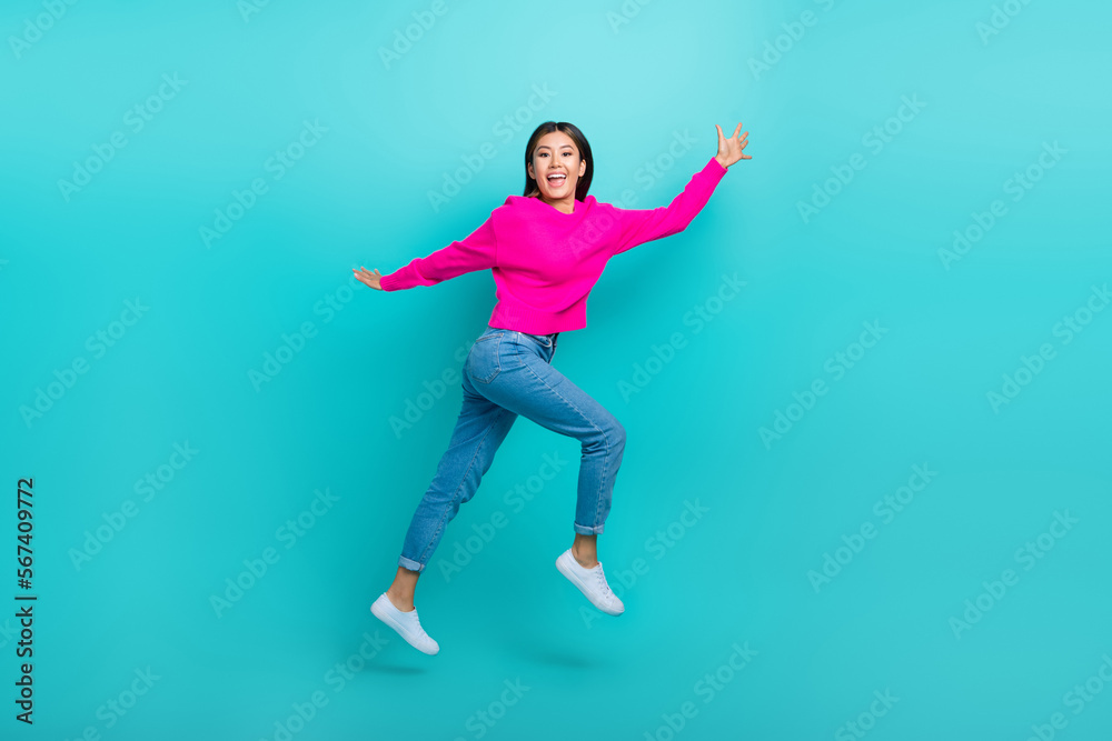 Full length photo of shiny pretty girl dressed pink pullover hurrying jumping high isolated teal color background