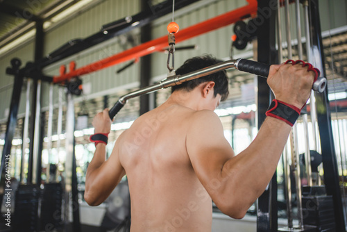 Asian man exercising with a barbell in the fitness