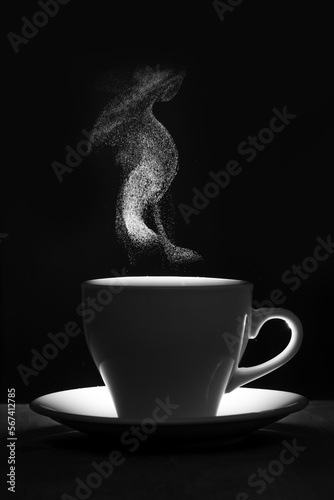 A white mug of warm drink and steam. Steaming coffee cup on black background, silhouette. A cup of hot coffee