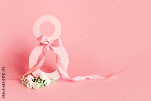 Paper cut eight with ribbon on pink background. Postcard March 8 on a pink background © Evgenia