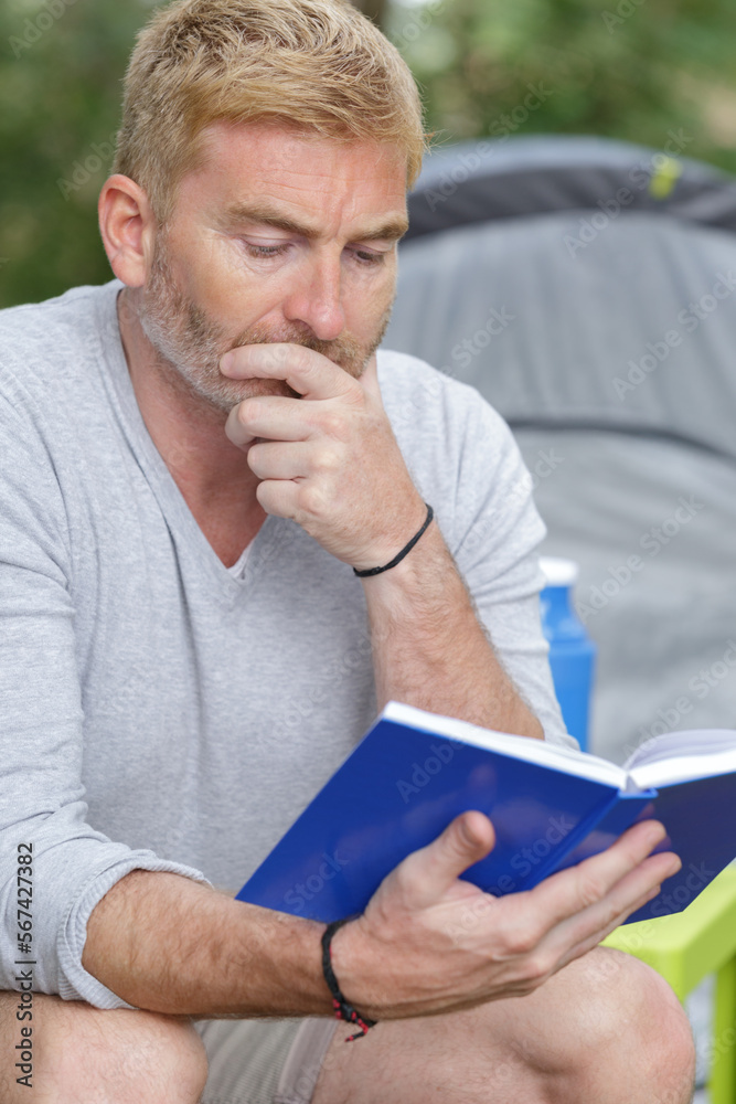 tourist reading a book in the forest tourist reading a book in the forest
