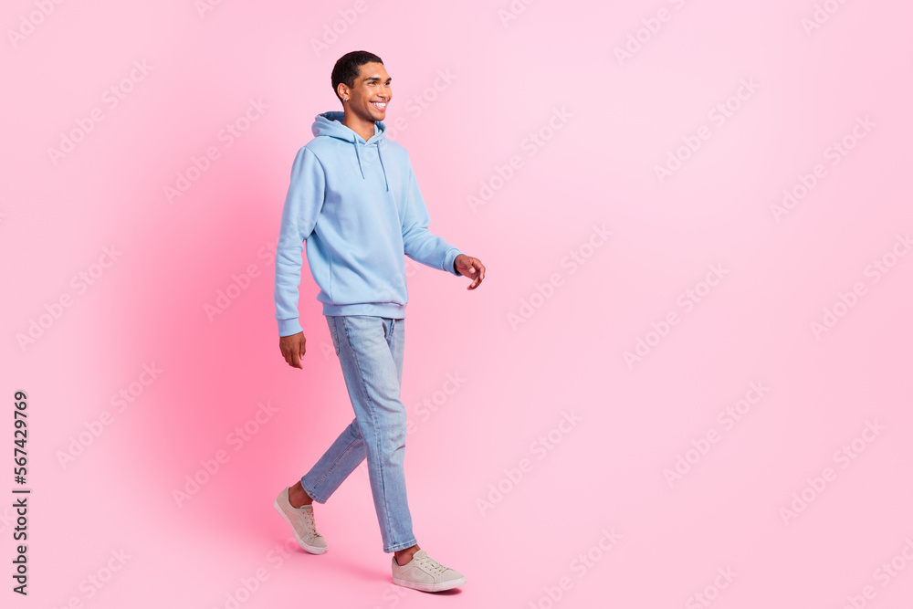 Full length photo of joyful nice man wear blue outfit moving empty space go party enjoy holiday weekend isolated on pink color background Full length photo of joyful nice man wear blue outfit moving empty space go party enjoy holiday weekend isolated on pink color background