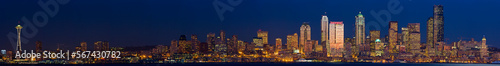 Panoramic skyline of Seattle with buildings reflecting the setting sun.