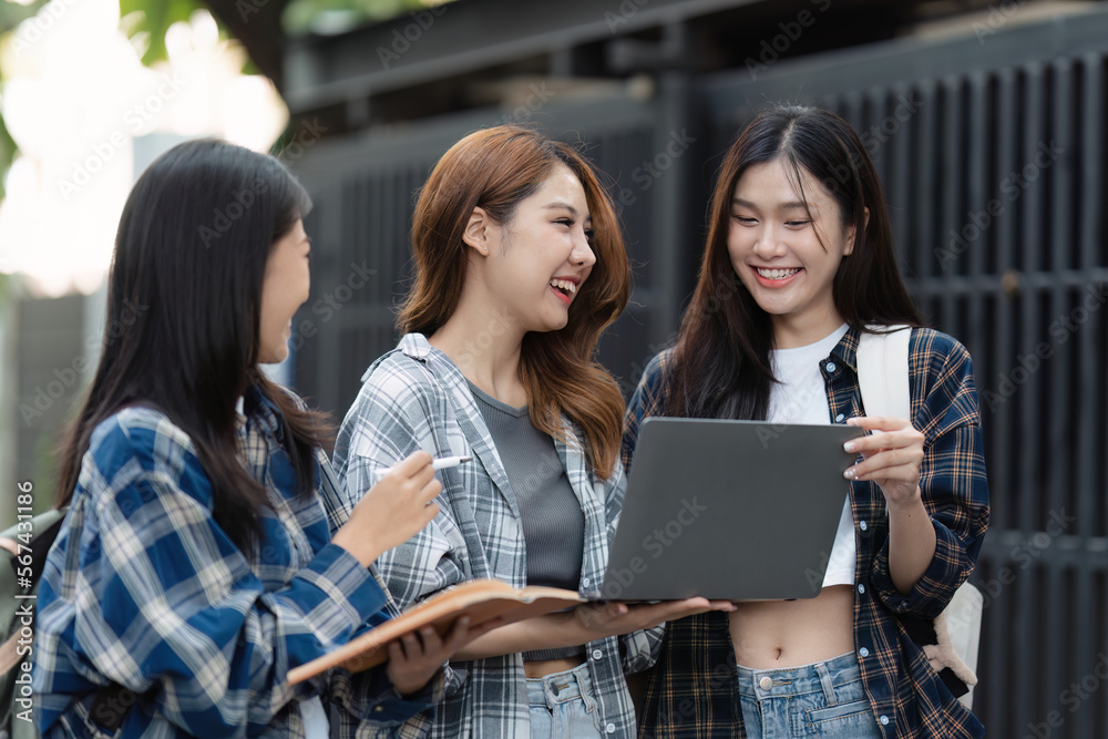 Beautiful young Asian woman college student with friends at outdoors. College student working on the college campus Beautiful young Asian woman college student with friends at outdoors. College student working on the college campus