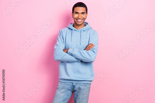 Photo of satisfied glad young man beaming smile crossed arms posing isolated on pink color background