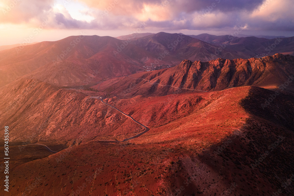 Fototapeta premium Volcanic mountains and red canyon at sunset (aerial view)