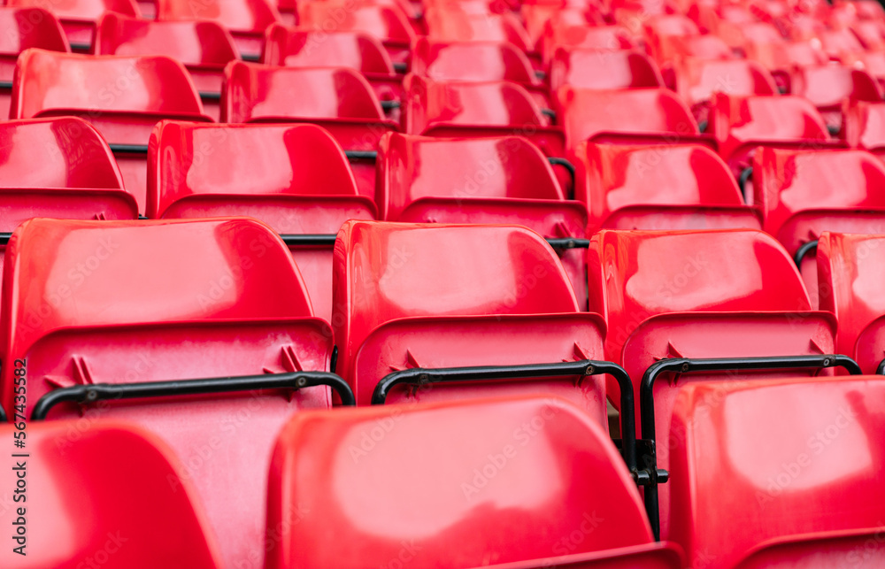 Obraz premium red plastic chair in football, basketball or baseball arena stadium in a row for visitor to visit and enjoy sport match competition for big football match in football stadium