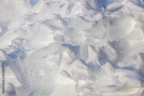 a pile of melting snow in a park in nature as a background