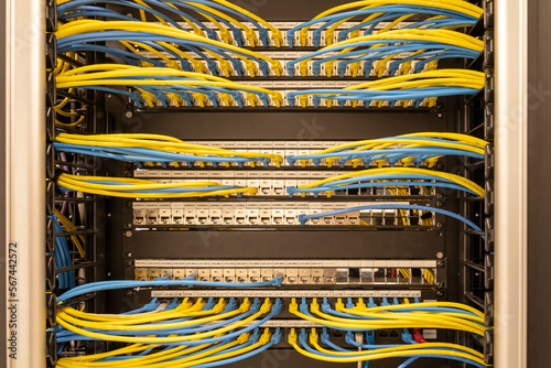 Front view on neat and tidily patched network cables, RJ45, connected to the switches and routers mounted on the rack in data centre, networking