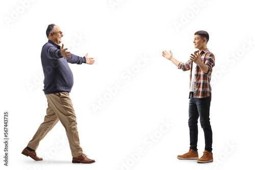 Full length profile shot of a male teenager waiting to hug his father