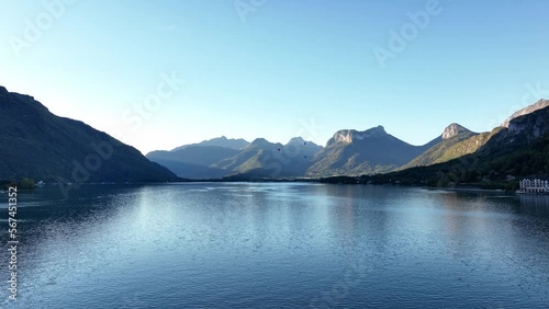 Incredible landscape of mountains and lake with hot air balloons in the background.
