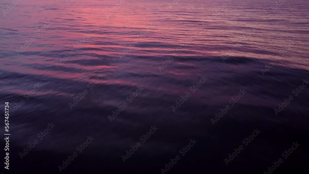 Drone flight over a calm sea focusing on the ocean waves with an epic sunset sky. Drone flight over a calm sea focusing on the ocean waves with an epic sunset sky.