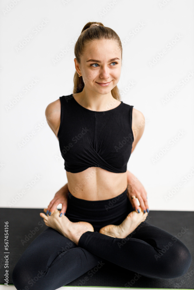 Morning yoga session, a woman sits in a lotus position on a mat.