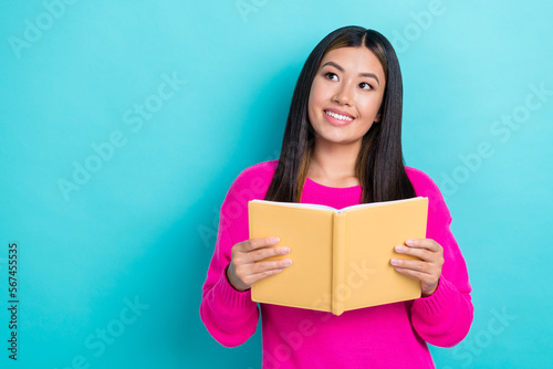 Photo of pretty cute lady wear trendy clothes hold book interested look empty space sale discount isolated on cyan color background
