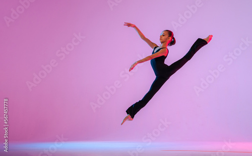 Canvas Print teenage girl in a tight black costume dancing a modern contemporary contemporary dancer isolated on a background in neon light