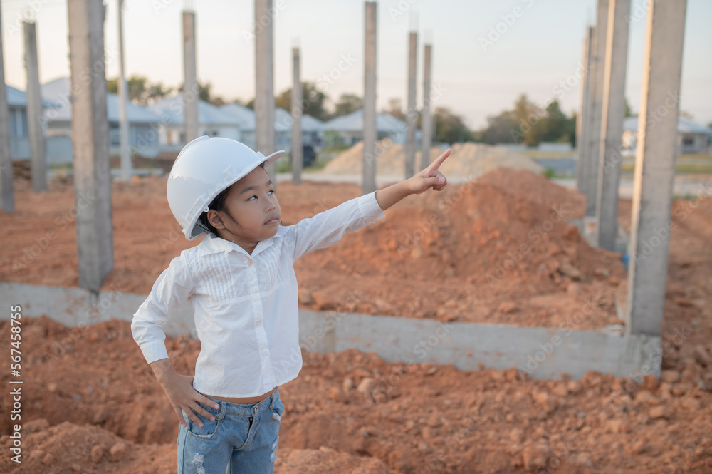 Engineer kid concept,Asian little girl wear engineer uniform working at site of building