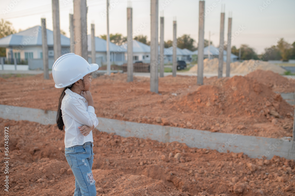 Engineer kid concept,Asian little girl wear engineer uniform working at site of building Engineer kid concept,Asian little girl wear engineer uniform working at site of building