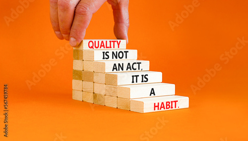 Quality is a habit symbol. Concept words Quality is not an act it is a habit on wooden blocks. Beautiful orange table orange background. Businessman hand. Business quality is habit concept. Copy space