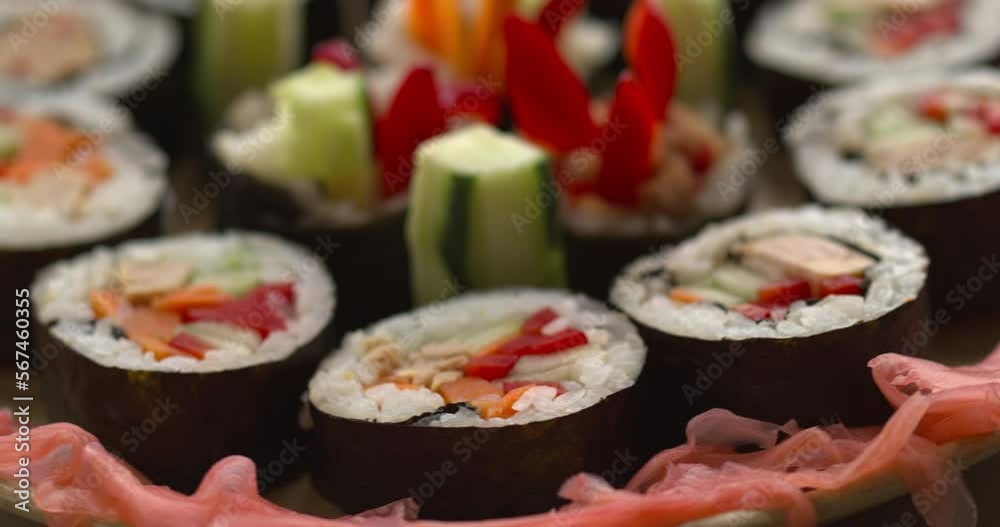Homemade futomaki maki sushi rolls with vegetables and canned tuna fish close-up view. Table spin. Seamless loop.