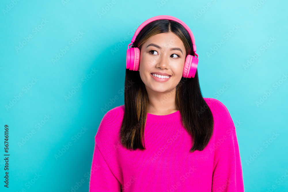 Portrait of cute lovely lady stylish pink clothes interested look empty space cool offer low price earbud isolated on cyan color background Portrait of cute lovely lady stylish pink clothes interested look empty space cool offer low price earbud isolated on cyan color background