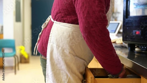 An employee stealing cash from a cash register in a restaurant.
