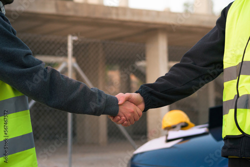 Two workers reach an agreement. Hands intertwined on a construction site