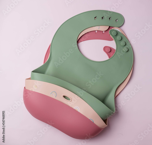 A set of colored silicone bibs for babies. Baby feeding and nutrition concept. Top view, flat lay.