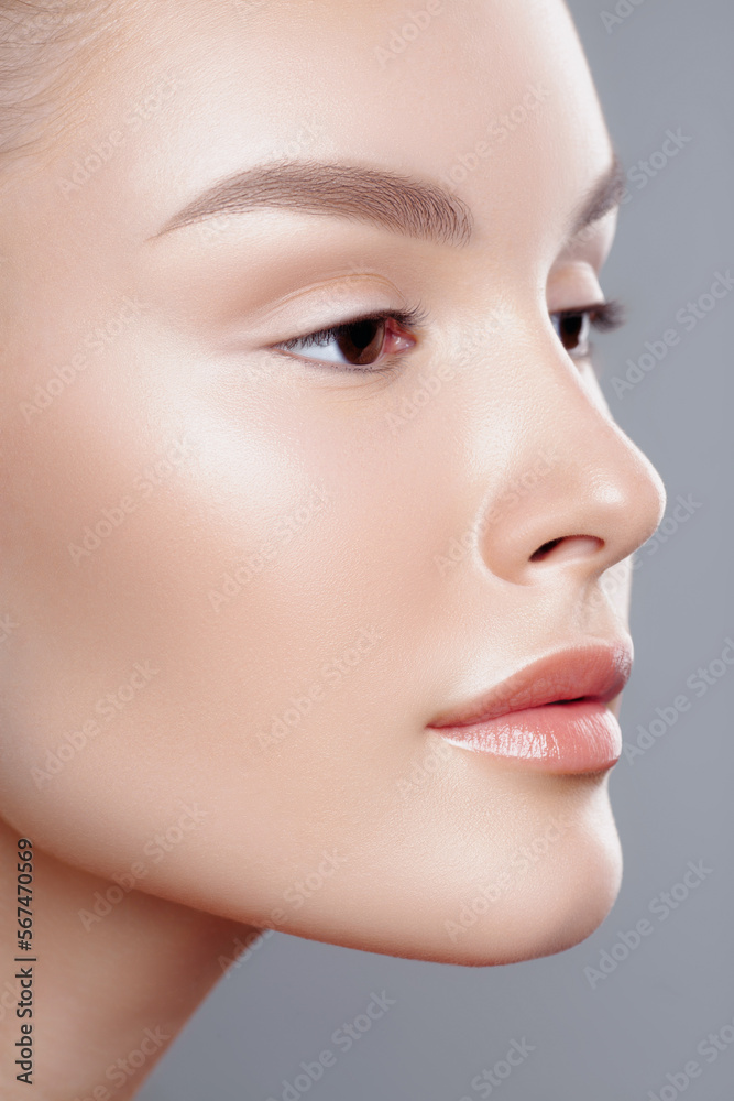 Face of young beautiful woman in closeup. Clear skin, nude makeup