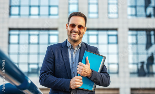 Smiling businessman in front of the corporation. Business, lifestyle concept