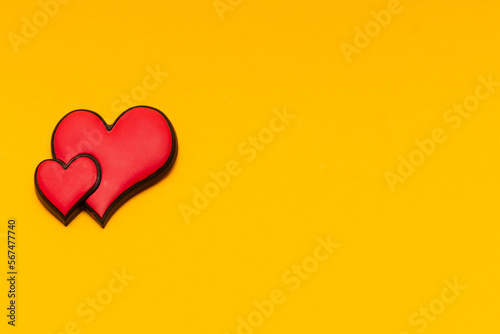 Obraz na płótnie Two red hearts on a yellow background with copy space. Place for text. Postcard for congratulations. Valentine's Day. w salonie