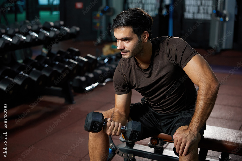 young sports man lifting dumbbell in the gym young sports man lifting dumbbell in the gym