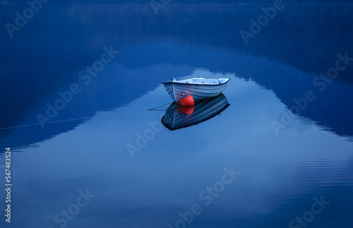 small boat on the lake in the blue hour