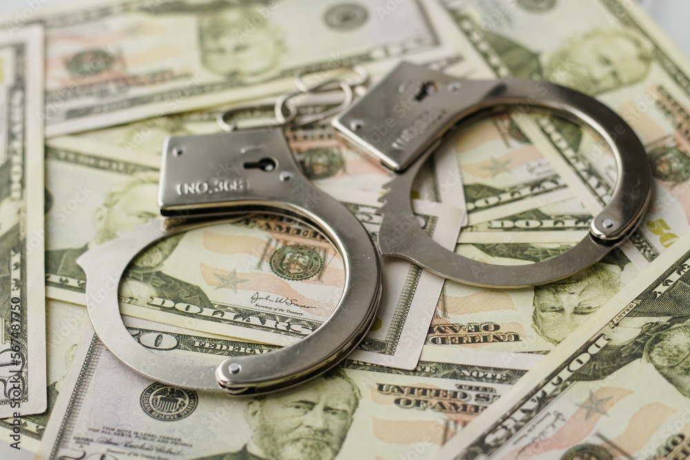Police handcuffs on dollar bills. Crime and bribery concept with handcuffs. Police handcuffs on dollar bills. Crime and bribery concept with handcuffs.